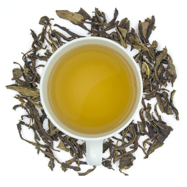 Limeade green tea bold and big tea leaves with brew in a cup that has yellow golden appeience